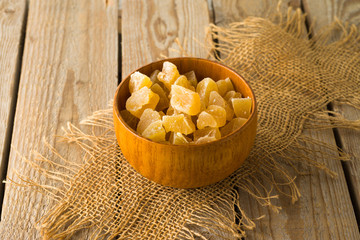 Food and healthy eating concept. Dried ginger with sugar on wooden table
