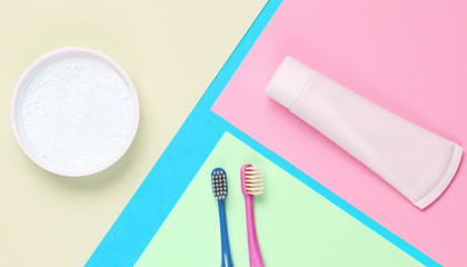 Minimalistic oral hygiene concept. Two toothbrushes with a tube of toothpaste, tooth powder on a...