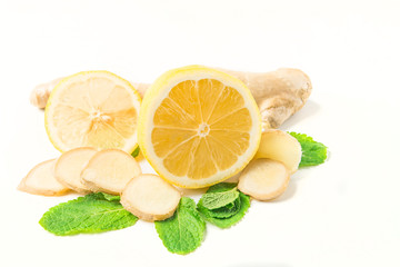 Glass jar of honey and dipper with ginger, mint, carnation, cinnamon and lemon isolated on a white background with space for text 