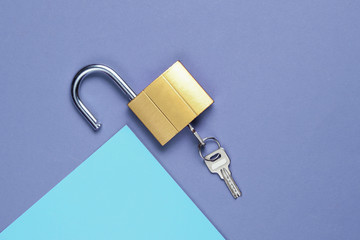 Lock and key on purple-blue background. Minimalistic concept. Top view
