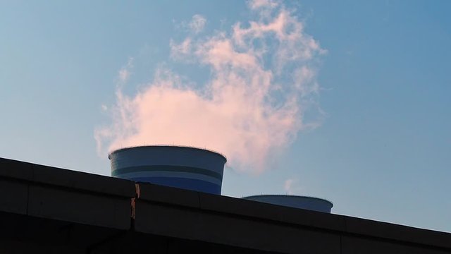 Close up of a smokestack / cooling tower from a nuclear power plant in China emitting a plume of white smoke