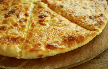 Closeup Fresh Baked Cheese-filled Georgian Flatbread Khachapuri Imeruli (Imeretian) on Wooden Plate