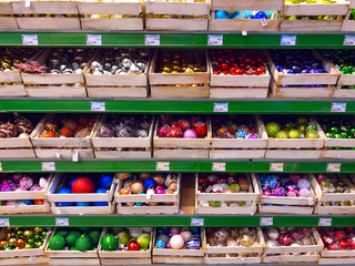 Assortment of Christmas tree decorations lying in a showcase in a supermarket