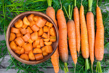 fresh carrots on wooden table after harvesting, cooking for vegetarians, healthy food. Growing vegetables in garden