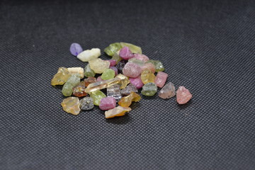 Mixed minerals stone on a black fabric background.