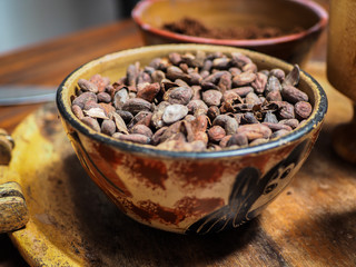 Roasted cocoa beans on a wooden, beautiful, bowl.