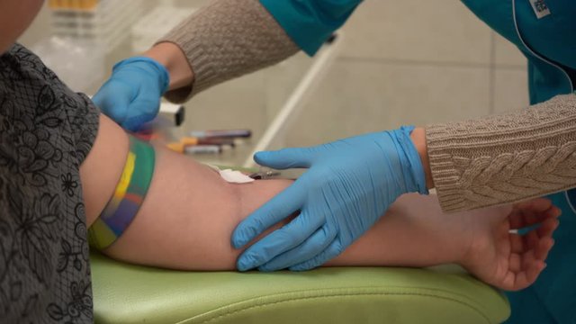 A teenage girl gives blood for analysis. Blood sampling from a vein.