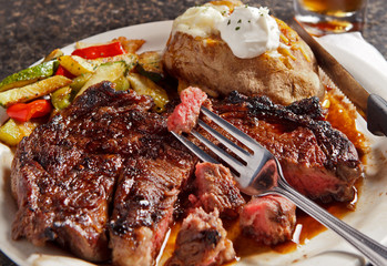 Steak cooked rare with baked potato
