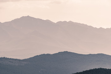 silhouette of mountain range in haze on horizon in mountain valley. Hiking in wild