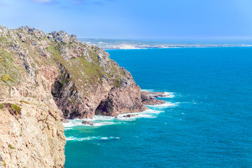 Fototapeta na wymiar Cliffs over the Atlantic ocean. The westernmost point in Europe. The edge of the land. Cape Roca (Cabo da Roca), Portugal
