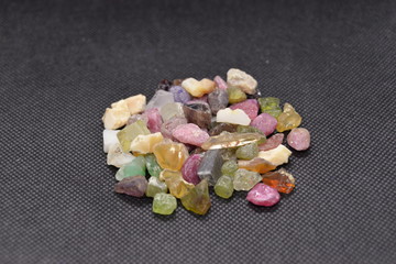 Mixed minerals stone on a black fabric background.