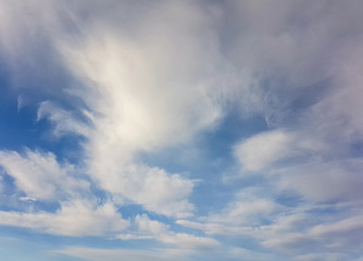 Naklejka na ściany i meble White clouds against a clear blue sky.