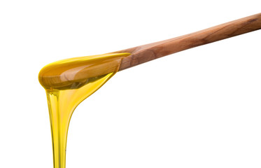 Falling and flowing honey on a wooden spoon isolated on white with clipping path