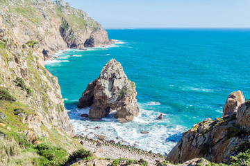 Fototapeta na wymiar Cliffs over the Atlantic ocean. The westernmost point in Europe. The edge of the land. Cape Roca (Cabo da Roca), Portugal