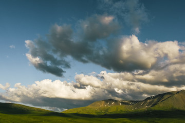 Obraz na płótnie Canvas cumulus clouds over rock ridge, waiting for rain in mountain valley
