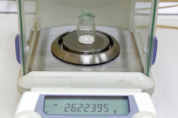 Precise reagent weighing on electronic laboratory balance. Laboratory equipment for chemistry,...