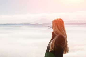young woman enjoys a beautiful view of the mountains from the top of the mountain - Powered by Adobe