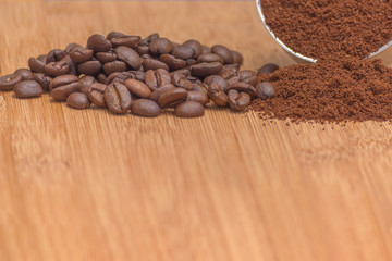 Coffee beans and ground powder on a wooden background. Top view with copy space