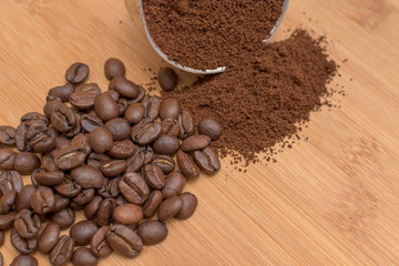 Coffee beans and ground powder on a wooden background. Top view with copy space
