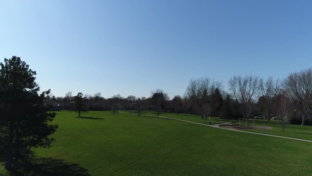 Flying Straight Up Opver Park With Pathways And Playground Near Neighborhood