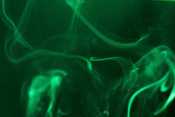 Mystic smoke patterns moving in colour on black background.