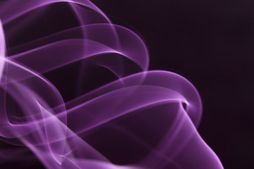 Mystic smoke patterns moving in colour on black background.