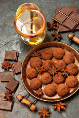 Whiskey or cognac, truffle chocolate candies in cocoa powder and dark chocolate