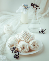 Handmade air russian fruitwhite marshmallow on a white background with beautiful bottles and dry berries. Homemade Sweets.