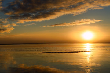 Setting sun over calm water of the Beaufort Sea at Barter Island Kaktovik Alaska