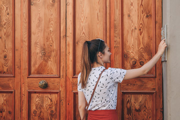 The girl calls the intercom for access inside the house.