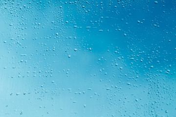 Blue window glass with water drops 