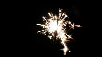 Fototapeta premium Close-up of firework sparkler burning. Fireworks burn on a black background