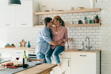 Happy couple embracing in kitchen