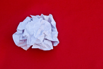 Wad of crumpled paper used on a bright red background close-up