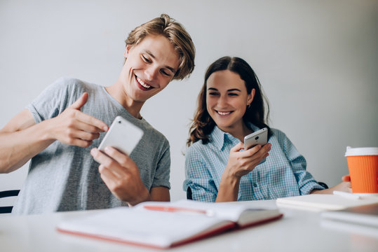 Happy Male And Female Bloggers Discussing Information From Funny Publication During Networking Time For Socialising Via Virtual Platforms For Communicate, Cheerful Hipster Guys Enjoying Mobility