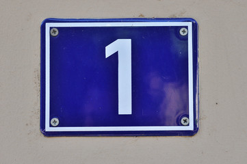A house number plaque, showing the number one (1)