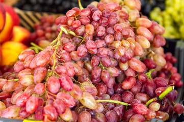 brushes of red large grapes lie in a heap on a counter eastern bazaar close-up