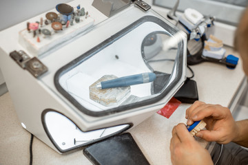 Dental technician working on gypsum jaw at the laboratory