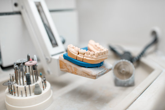 Artificial jaw for implants modeling with set of dental burs at the working place of dental technician in the laboratory