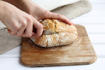 the cook cuts a piece of fresh bread. daily kitchen chores