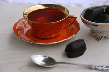 Obraz na płótnie Canvas Hot tea cup and chocolate candy
