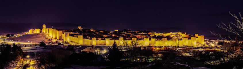 Fototapeta na wymiar Ávila al anochecer con su muralla medieval iluminada (España).