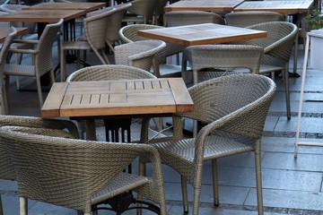 On the street are tables and wicker chairs.