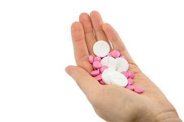 multicolored tablets of different size in hand top view close-up macro, isolated, white background
