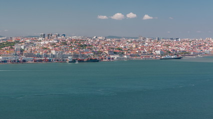 Fototapeta premium Panorama of Lisbon historical centre aerial timelapse viewed from above the southern margin of the Tagus or Tejo River.