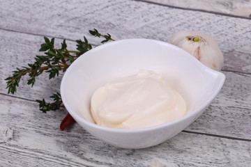Mayonnaise sauce in the white bowl served thyme and garlic