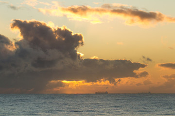 Dawn sky over the North Sea with orange light and clouds.