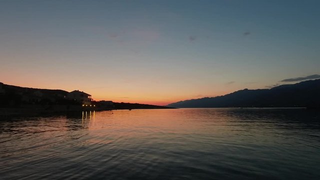 Tranquil view of colorful sunset and waterfront home on the calm bay