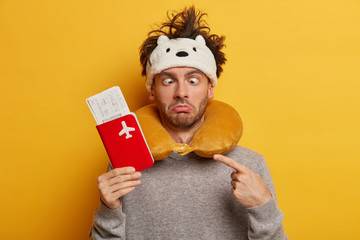 Crazy funny passenger crosses eyes, has messy hair, wears neck pillow for comfort during plane...