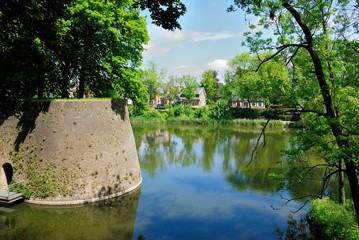 View of Kasteelgracht canal, the Rampart fortification wall and some Flemish houses at the back on...